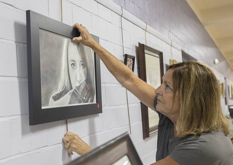 Shirley Vivian hangs a work Monday, April 13, 2026, for the annual Phidian Art Club’s 2026 show. Work can still be submitted Tuesday from 2-6pm at the Loveland House in Dixon. Awards will be handed out Thursday with doors opening at 6pm for public viewing.
