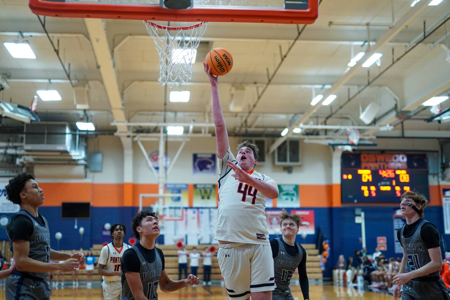 Oswego’s Hunter O’Neill (44) powers to the basket against Oswego East's Damien Lewandowski (10) and Lukas Adolfs (12) during a basketball game at Oswego High School on Tuesday, February 18, 2025.