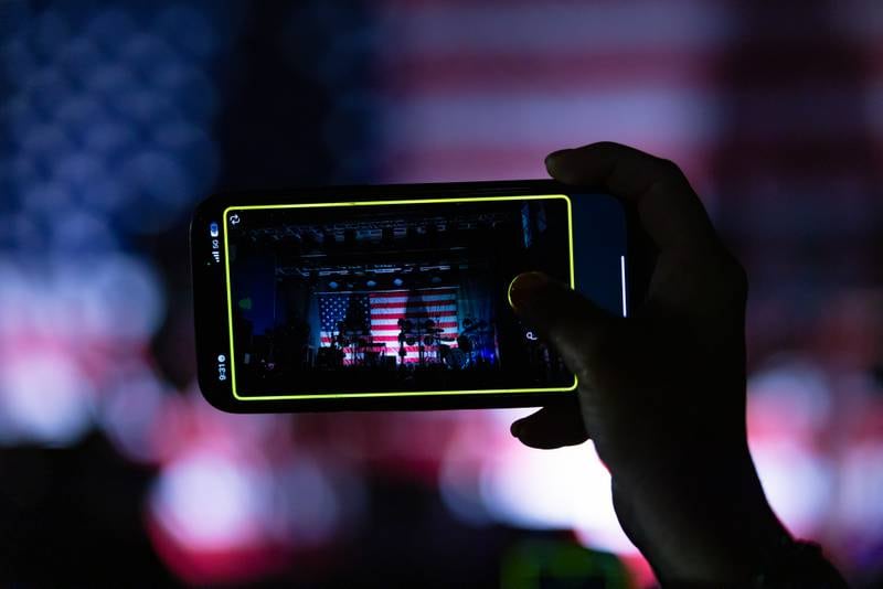 A concert attendee takes a Snapchat of the stage as the Pledge of Allegiance plays prior to Aaron Lewis starting his show at Streator Fest on August 1, 2025.