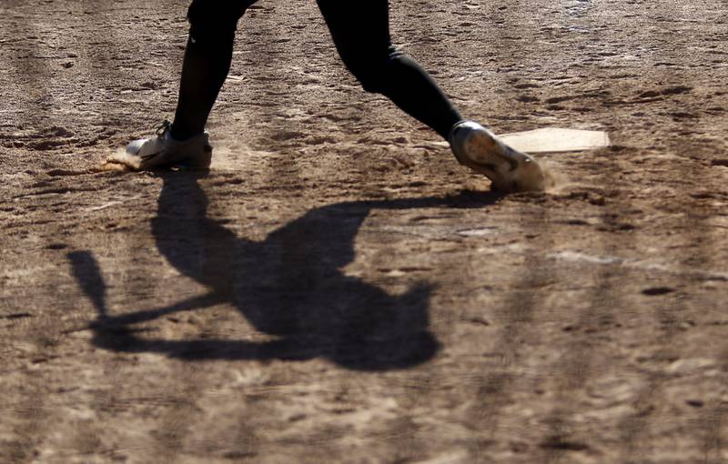 Huntley's Piper Heimbrodt’s shadow is cast on the ground as he tries to hit the ball during a Fox Valley Conference softball game against Hampshire on Thursday, May 14, 2026, at Huntley High School.