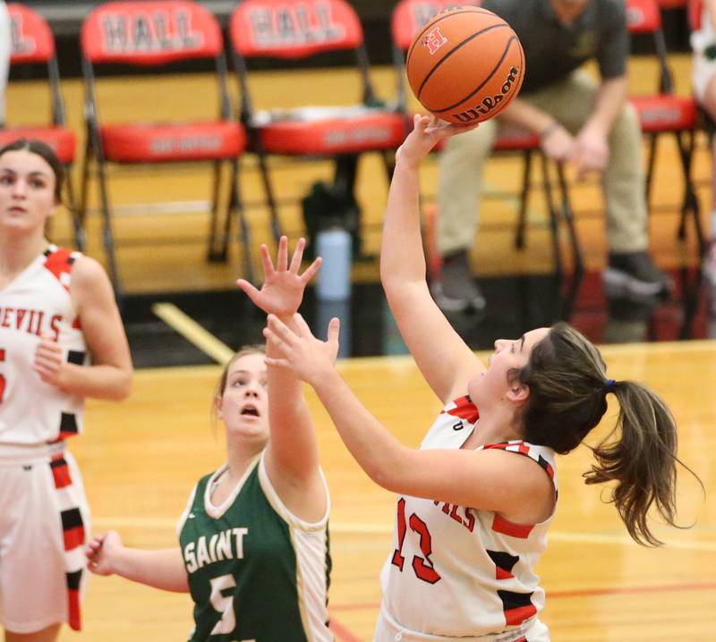 Hall's Mckenna Christiansen (13) runs past St. Bede's Sadie Koehler (5) to score on a layup on Monday, Nov. 28, 2022 at Hall High School in Spring Valley.
