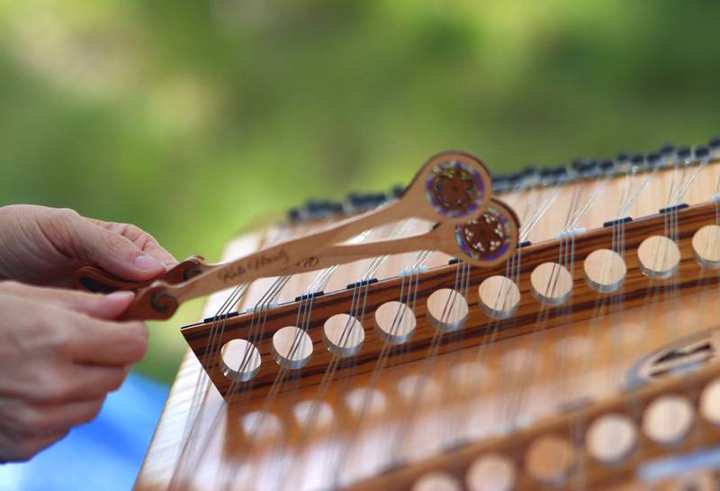 Katie Moritz of Yorkville warms up on the hammered dulcimer during the Fox Valley Folk Music & Storytelling Festival at Wheeler Park in Geneva on Sunday, August 31, 2025. Moritz played music as part of the Bill Robinson and Friends musical group at the event.