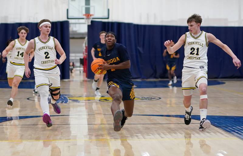 Neuqua Valley's David Taiwo (5) drives to the hoop against Yorkville Christian's Brady Sovern (2) and Jordan Purvis (21) during a basketball game at Yorkville Christian High School on Tuesday, February 4, 2025.