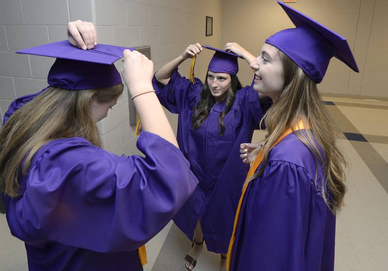 Graduates Elizabeth Schillinger, Mileigh Schultz and Alex Stremlau help each other before the graduation ceremony Saturday, May 14, 2022, at Mendota High School.