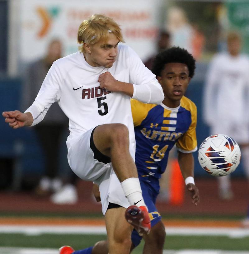 Prairie Ridge's Brandon Matei kicks the ball aways from Chicago De La Salle's Antonio Als during an IHSA Class 2A state semifinal soccer match on Friday, Nov. 8, 2024, at Hoffman Estates High School.