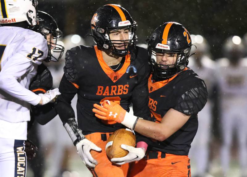 DeKalb's Ethan Tierney (left) and Daniel Roman-Johnson celebrate Tierney's interception during their game against Neuqua Valley Friday, Oct.14, 2022, at DeKalb High School.