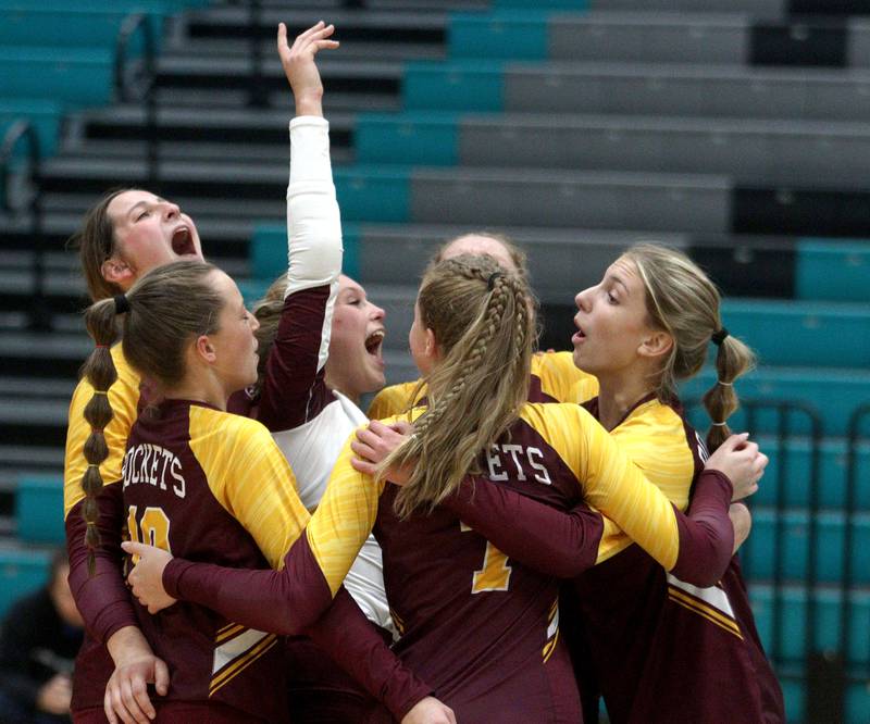 Richmond-Burton’s Rockets celebrate a three-set win in varsity volleyball at Woodstock North Monday night.