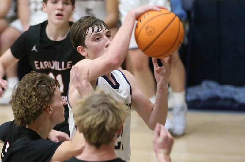 Marquette's Griffin Dobberstein runs in the lane while being guarded by Earlville defenders Gavin Guelde and Adam Waite  on Friday, Jan. 3, 2025 in Bader Gym at Marquette High School.