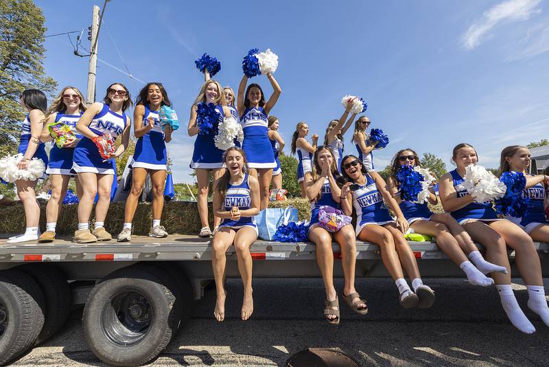 The Newman cheer squad rally their Comet pride Friday, Sept. 12, 2025, as they float through the homecoming parade.