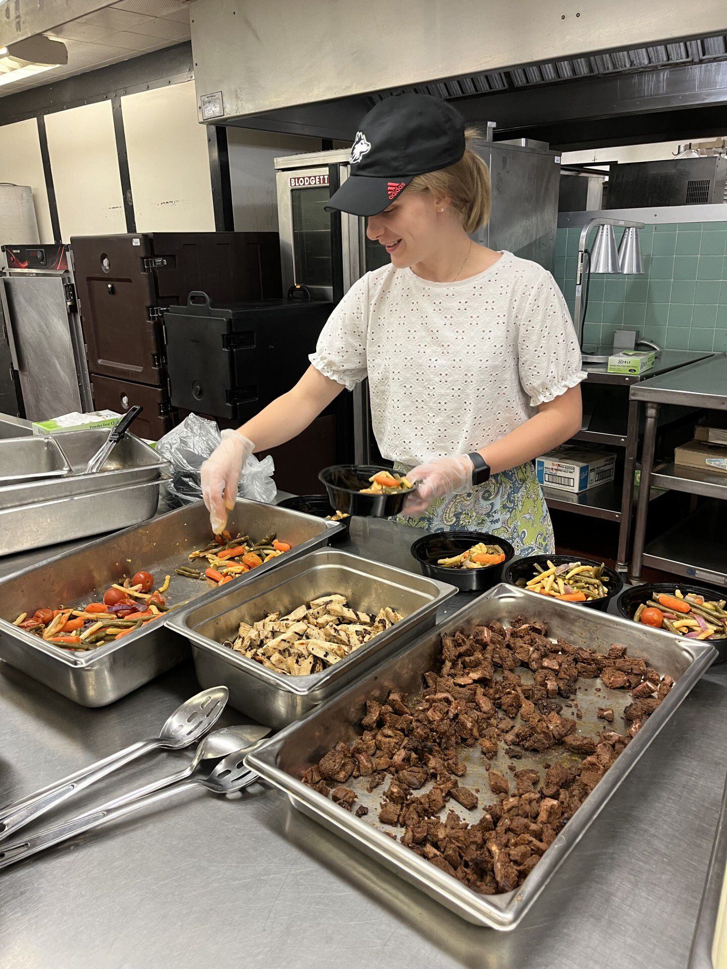 A student packages leftover food into ready-to-go frozen meals for students to enjoy for free through Northern Illinois University's Huskie Harvest program. The initiative aims to reduce food waste and address food insecurity.
