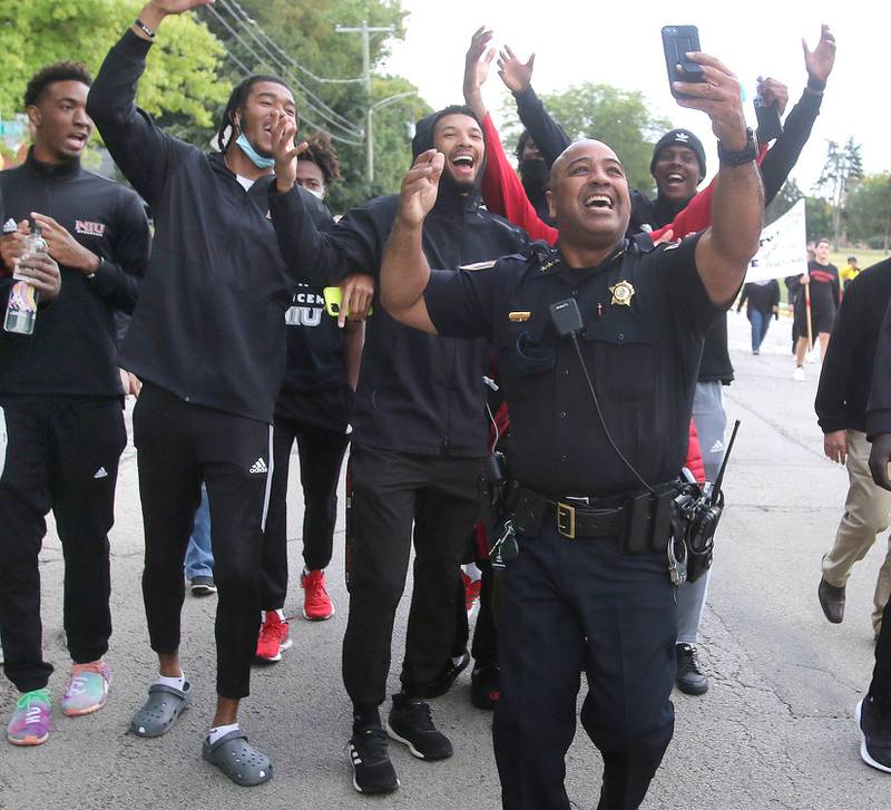 DeKalb Police Chief David Byrd films a TikTok with members of the Northern Illinois University mens basketball team as they along with other students and officials participate in the NIU Unity Walk Tuesday, Sep. 21, 2021 in DeKalb. The walk, which fell on the International Day of Peace and near the one-year anniversary of the Belonging initiative, started at the student center then proceeded down Lucinda Avenue to Russell Road then returned back down Normal Road and and finished at the Martin Luther King Jr. Memorial Commons.