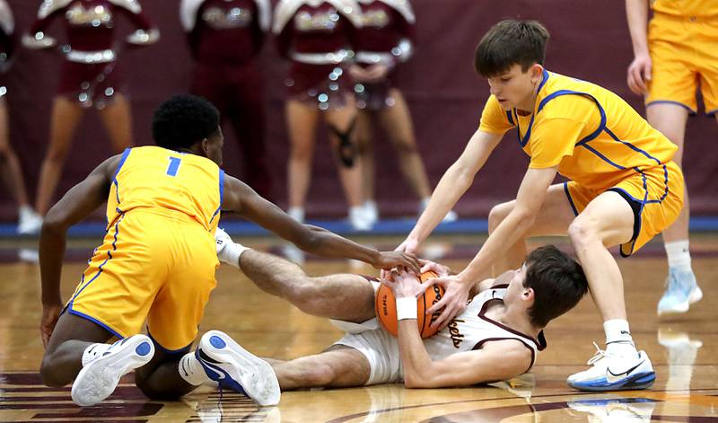 Johnsburg's Jarrel Albea (left) and Trey Toussaint (right) trie to get a jump ball call  with Richmond-Burton's Dane Gardner during a Kishwaukee River Conference boys basketball game on Tuesday, Jan. 27, 2026, at Richmond-Burton High School.