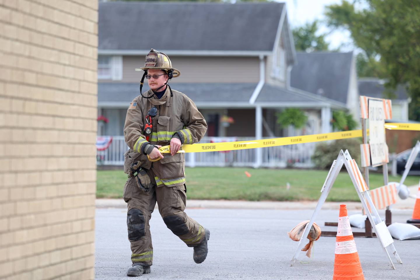Papineau Fire Department Lt. Bruce Lane sets up caution tape a block from where a concrete grain bin collapsed on Wednesday, Oct. 15, 2025, at the Donovan Farmers Co-Op Elevator in downtown Martinton.