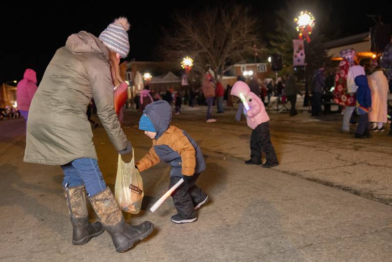 Angela Rodriguez and son Merrick collect candy thrown at the end of the Christmas Parade on December 7, 2025 in Spring Valley.