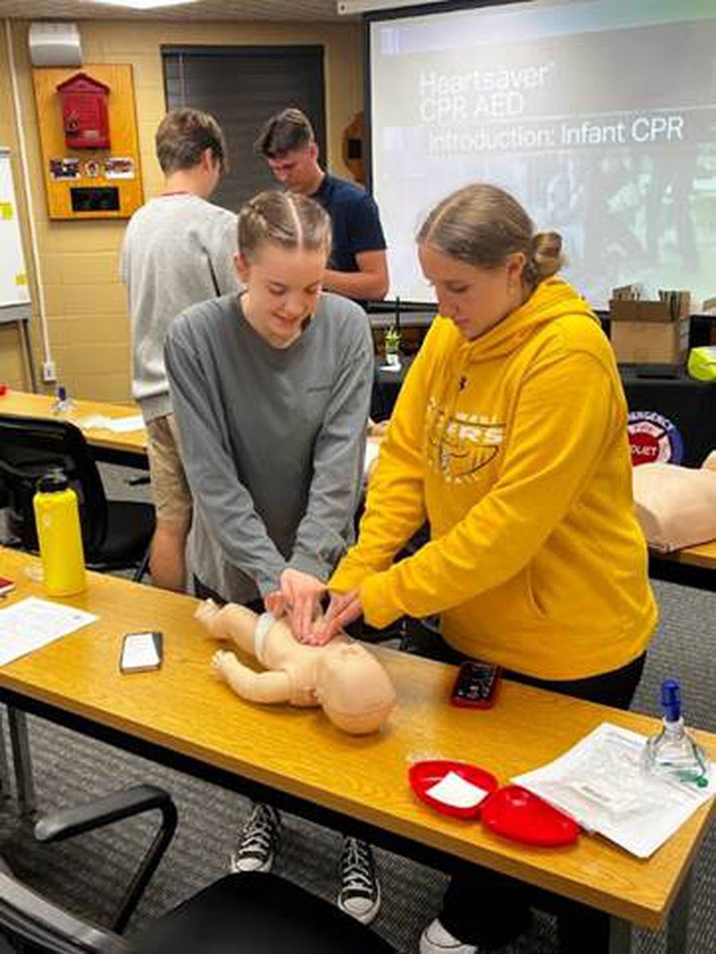 Camdyn Kranz (left) and Brianna Sing (right) practiced infant CPR during the Joliet Fire Department Citizen Fire Academy. All participants in the 
fire academy were certified in the American Heart Association Heartsaver First Aid CPR AED program for adults, children and infants.