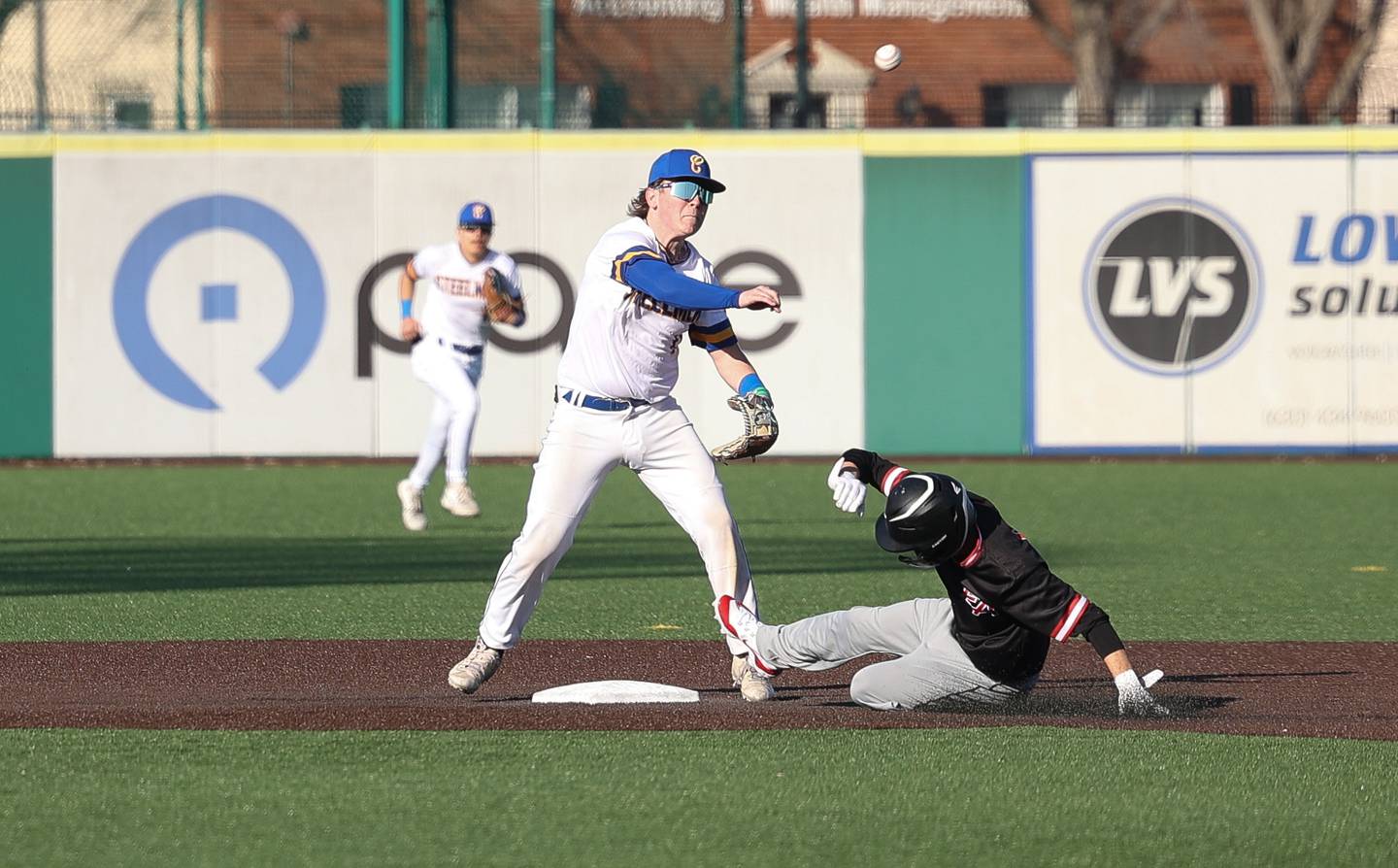 Joliet Central’s John Stasiak throws to first to complete a double play against Aurora East on Monday, Mar. 11th in Joliet.
