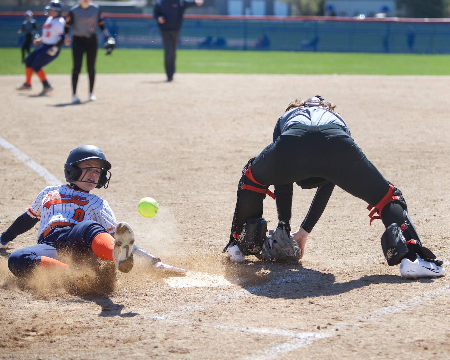 Oswego's Maddie Hernandez slides into hime safely as the ball gets past Wheaton Warrenville South's Mallorie Durian on Saturday, April 6, 2024 in Oswego.