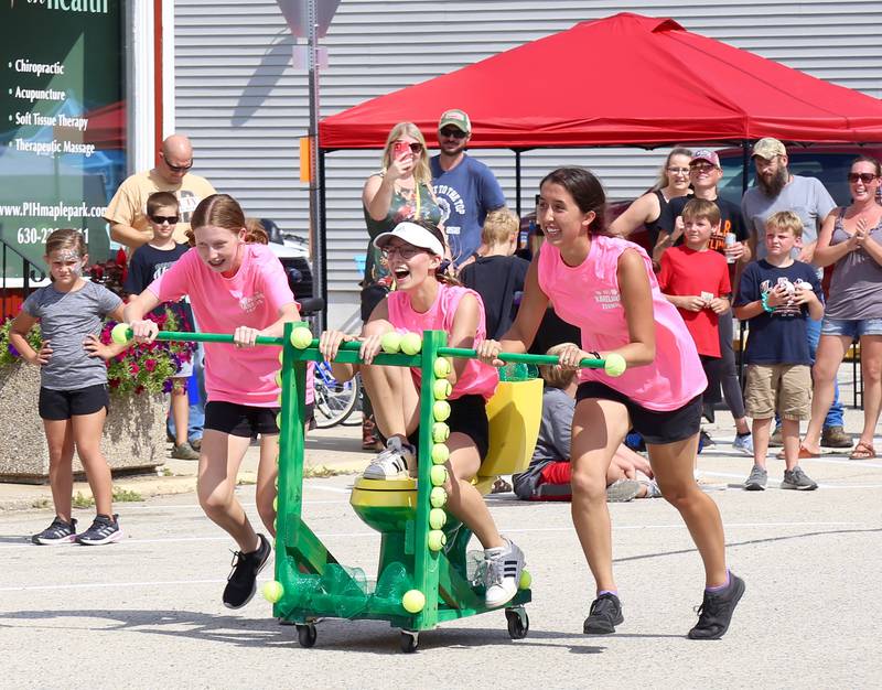 Team Long Deuce (l-r) Anna Bishop, Marisa Urban and Kassidi Catanag, participate in the Toilet Bowl Races at the Maple Park Fun Fest on Saturday, Sep. 3, 2022.