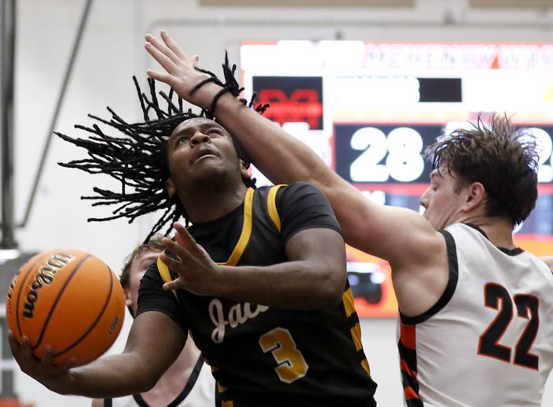 Jacobs' Emaan Thomas drives to the basket against McHenry's Conner McLean during an IHSA Class 4A McHenry Regional basketball game on Wednesday, Feb. 26, 2025, at McHenry High School.