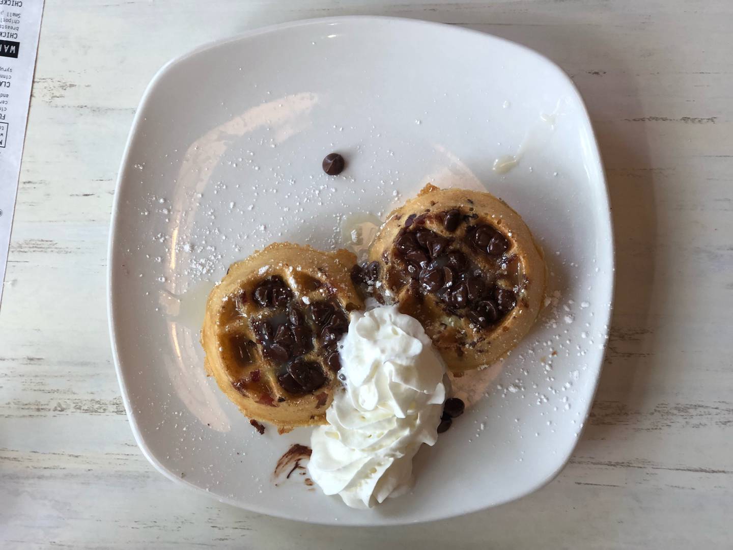 Side order of chocolate chip pancakes stuffed with bits of real topped off with whipped cream and chocolate drizzle at Syrup in Algonquin.