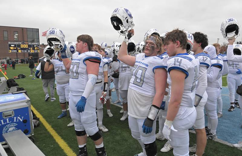 The St. Francis football team ritually sings to their fans with the scoreboard in the background showing their loss to Nazareth in the IHSA Class 5A state semifinal football game in La Grange on Saturday, Nov. 23, 2024.