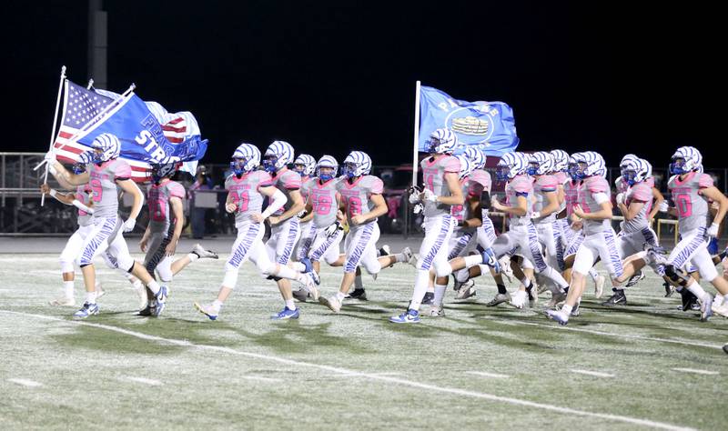 Members of the Princeton High School football team run onto the field on Friday, Oct. 11, 2024 at Mendota High School.