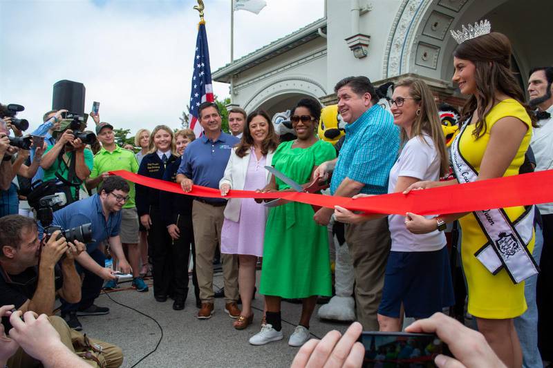 Gov. JB Pritzker, organizers of the Illinois State Fair and others cut the ribbon at the main gate of the Illinois State Fairgrounds last month.