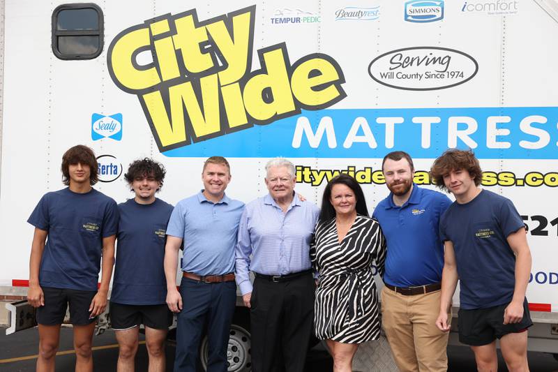 Cole Spivey, left, Joseph Borracci, Ross Brocies, Rck Brocies, DeAnna Borracci, Austin Parks and David Ribe pose for a photo in front of the City Wide Mattress delivery truck on Monday, June 12, 2023 in Shorewood.