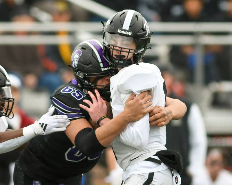 Downers Grove North's Aiden Solecki (65) tackles Fenwick's quartrback Frankie Hosty (1) on Saturday Nov. 9, 2024, during the second week of the class 3A game held at Downers Grove North High School.