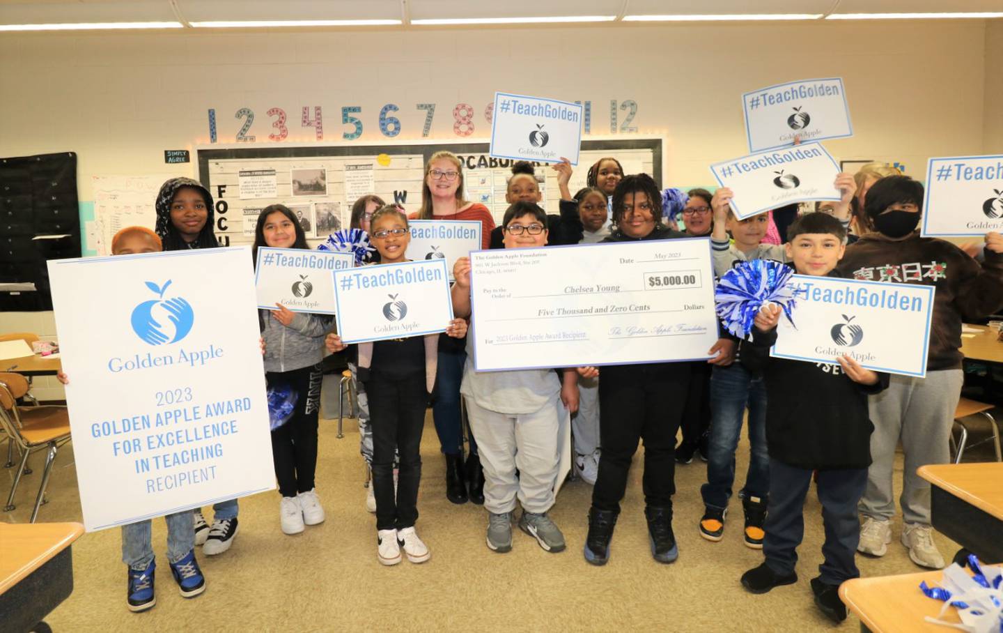 Woodland Elementary School teacher Chelsea Young celebrates receiving a Golden Apple Award with her fifth-grade students at the Joliet school on Wednesday.