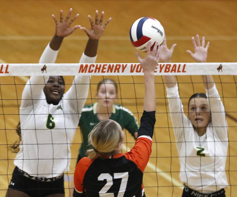 McHenry's Lily Ahrens (center) tries to hit the ball through the block of Crystal Lake South's Sahara Okirika (left) and Olivia Kouretsos (right) during a Fox Valley Conference volleyball match on Thursday, Aug. 28, 2025, at the Freshman Campus of McHenry High School in McHenry.