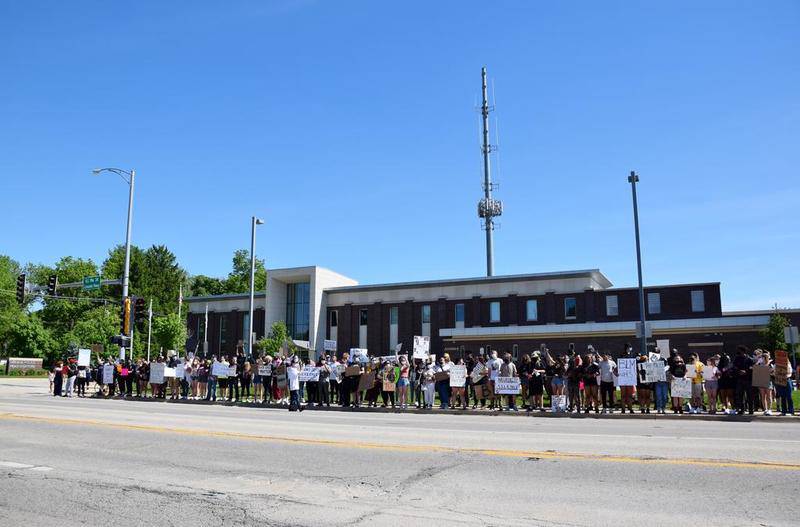 Hundreds of peaceful protesters link arms and chant in front of the DeKalb Police Station on May 31. The protest was held in response to the killing of George Floyd while in the custody of a Minneapolis police officer earlier this week.