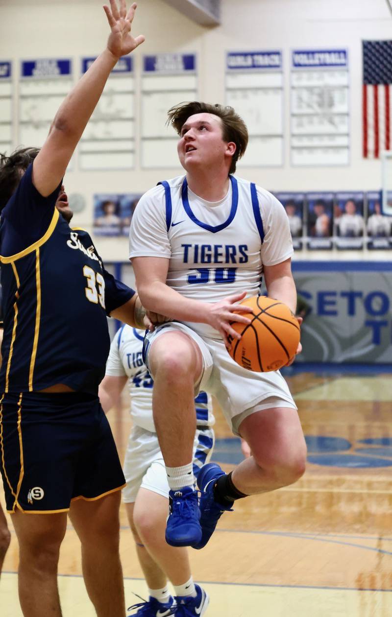 Princeton's Jordan Reinhardt drives on Sterling's Maddux Osborn Friday night at Prouty Gym. The Tigers won 56-47.