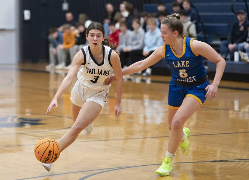Cary-Grove's Kennedy Manning pushes past the defense of Lake Forest's Chloe Hvostik during the Class 3A Cary-Grove Regional Girls Basketball Championship game on Thursday, February 20, 2025 in Cary. Ryan Rayburn for Shaw Local