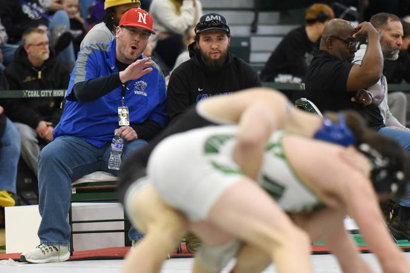 Central-Iroquois West wrestling coach Travis Williams, left, instructs Gianni Panozzo during his 150-pound championship match as assistant coach Dane Thorne also watches during the IHSA Class 1A Coal City Sectional Saturday, Feb. 15, 2025.