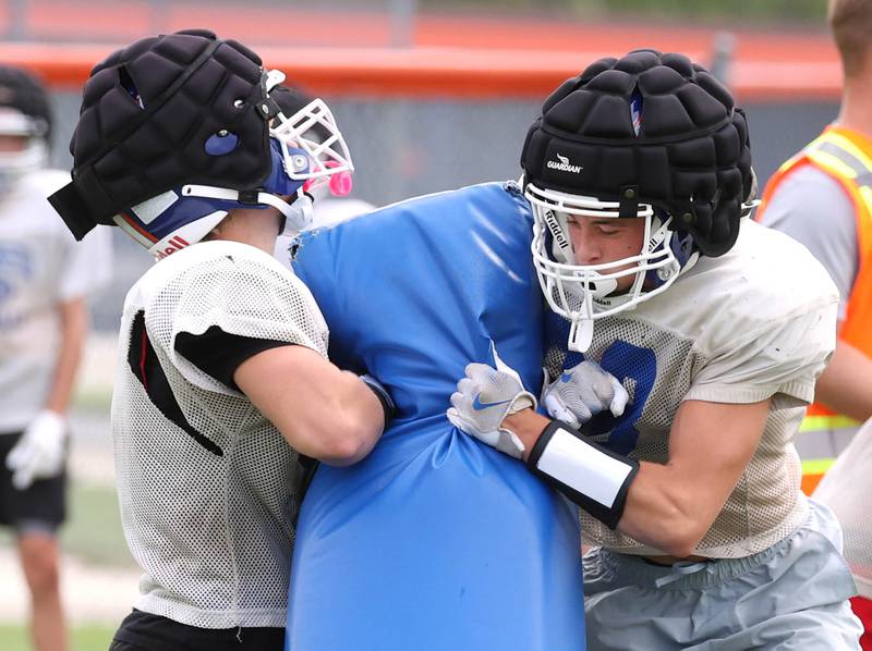 Genoa-Kingston’s Anthony Gum (right) throws a block Tuesday, Aug. 19, 2025, during practice at the school.