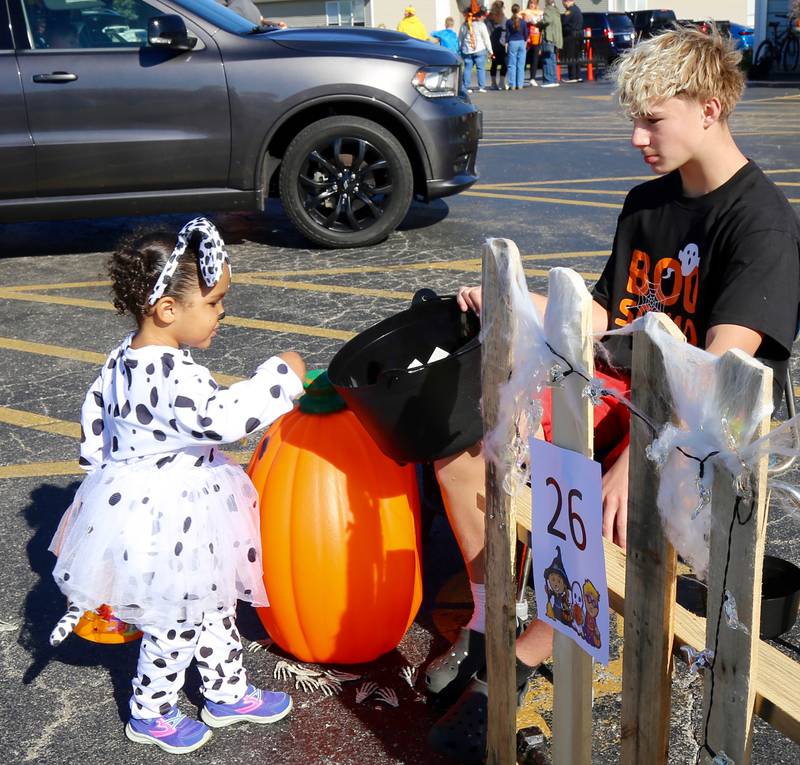 Kayleigh Sumerlin, 2-1/2, chooses a piece of candy at the Fox Valley Family YMCA West branch Trick or Trunk on Sunday, Oct. 26, 2025 in Sandwich.