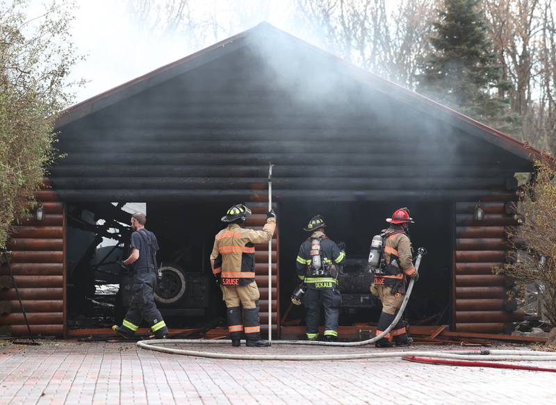 Firefighters work inside the garage of a house that was destroyed by fire Thursday, Nov. 13, 2025, near Shabbona Grove Road in Shabbona. Several local departments responded to the general alarm structure fire.
