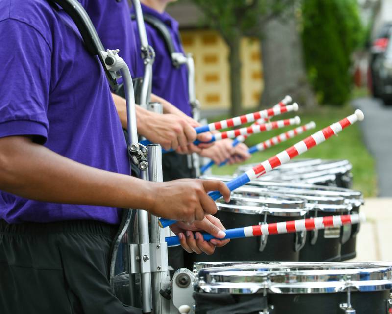 Downers Grove North and Downers Grove South marching band drummers use patriotic drumsticks during the Independence Day parade on Friday July 4, 2025, held in downtown Downers Grove.