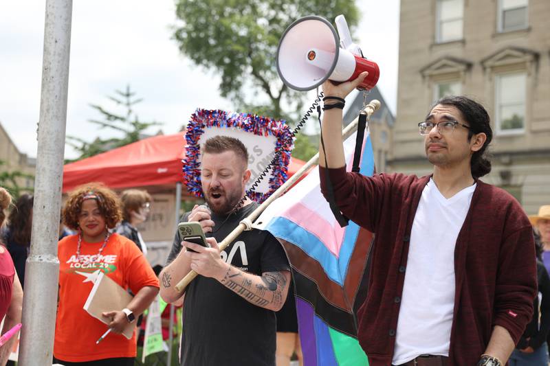 Matt Hedding-Hess, founder and president of the Kankakee Area LGBTQ Network, speaks to the approximately 500 people gathered at the Kankakee County Courthouse for a ‘No Kings’ rally in Kankakee on Saturday, June 14, 2025, to protest actions by President Donald Trump. Brandon Hudspeth-Perales, an organizer with Indivisible Kankakee, holds the megaphone.
