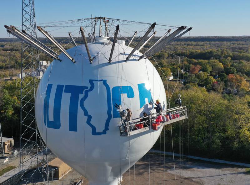 Crews paint the Utica water tower on Friday, Oct. 18, 2024 on top of Clarks Hill in Utica. The Village gave the approval to paint the tower and also conduct repairs inside and out. A Bald Eagle and the State of Illinois is featured on the tower.
