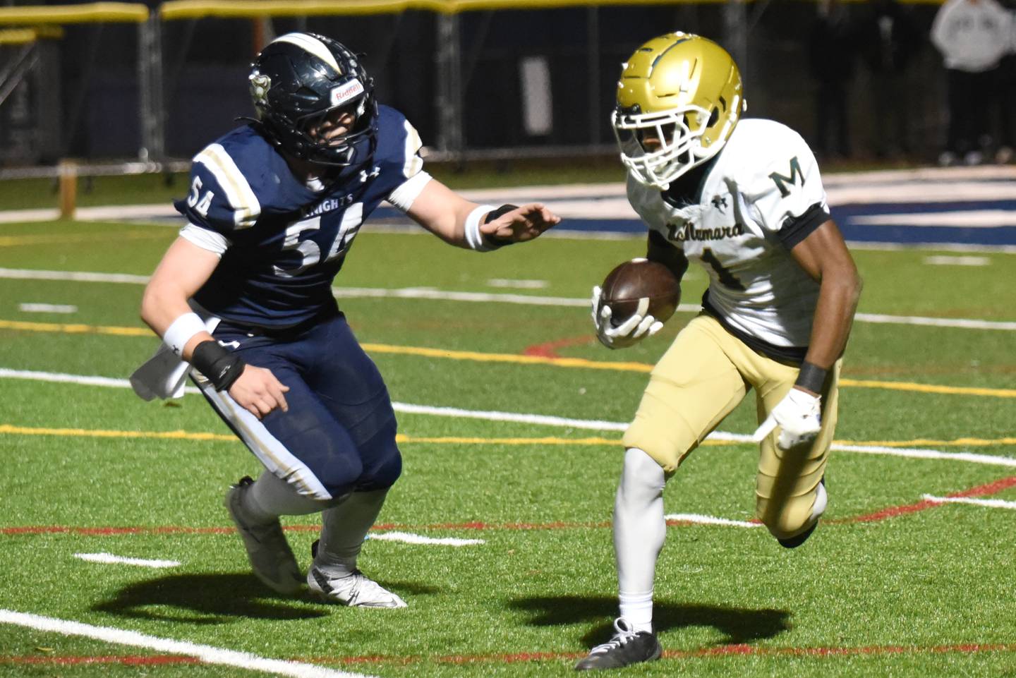 Bishop McNamara's Malachi Lee, right, looks to evade IC Catholic's Anthony Sebastian during an IHSA Class 3A second round playoff game at IC Catholic Friday, Nov. 7, 2025.