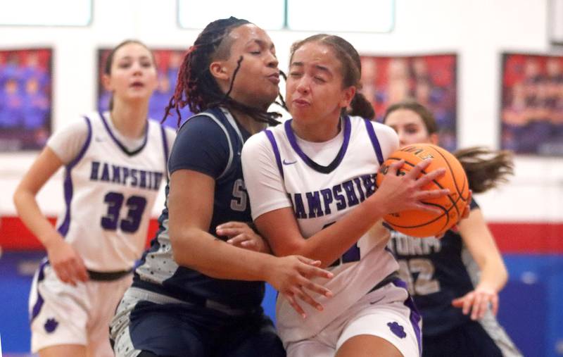 Hampshire’s Mikala Amegasse, right, drives as South Elgin’s Liv Miller defends in varsity girls basketball Komaromy Classic tournament  action on Monday, Dec. 29, 2025, at Dundee-Crown High School in Carpentersville.