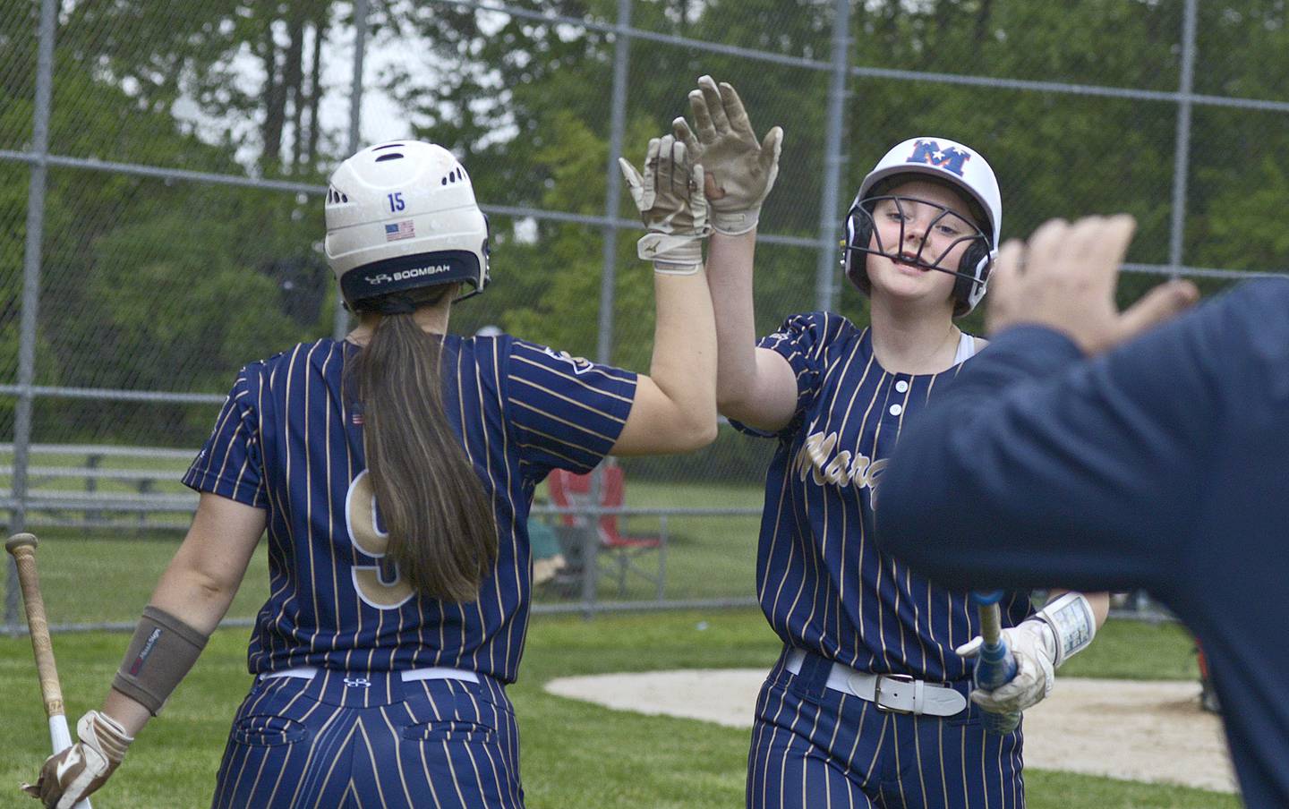 Marquette’s Kelsey Cuchra receives high fives as she makes her way to the dugout after scoring the Lady Crusaders 6th run Wednesday against Elgin St Edward at Serena.