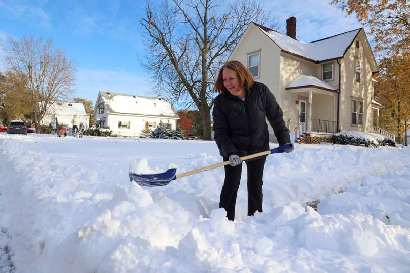 Cathy Lafond shovels the snow from the sidewalk in front of her Momence home after approximately 12 inches of snow fell in the early hours of Nov. 10, 2025.  Lafond said she can't recall the last time the city got so much snow this early in the year.