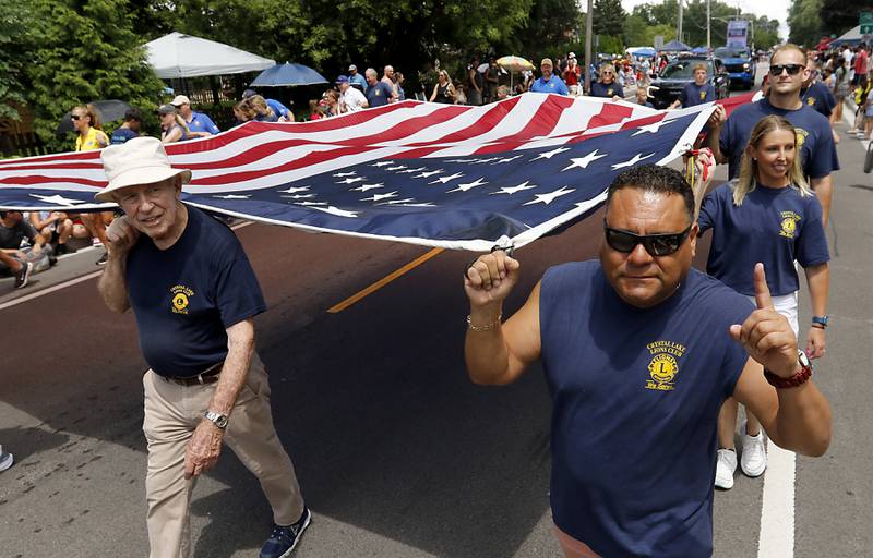 Ben Flores and other members of the Crystal Lake Lions Club carry the American Flag on Sunday, July 6, 2024, during Crystal Lake’s annual Independence Day Parade on Dole Avenue in Crystal Lake.