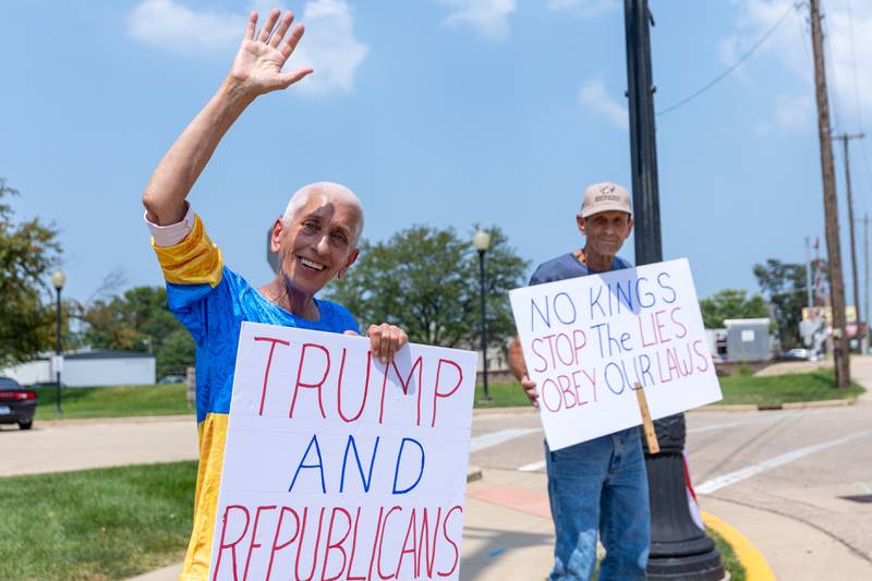 Protester waves while holding sign at the “No Kings” protest on Saturday,  August 9, 2025 at Rotary Park in Princeton.