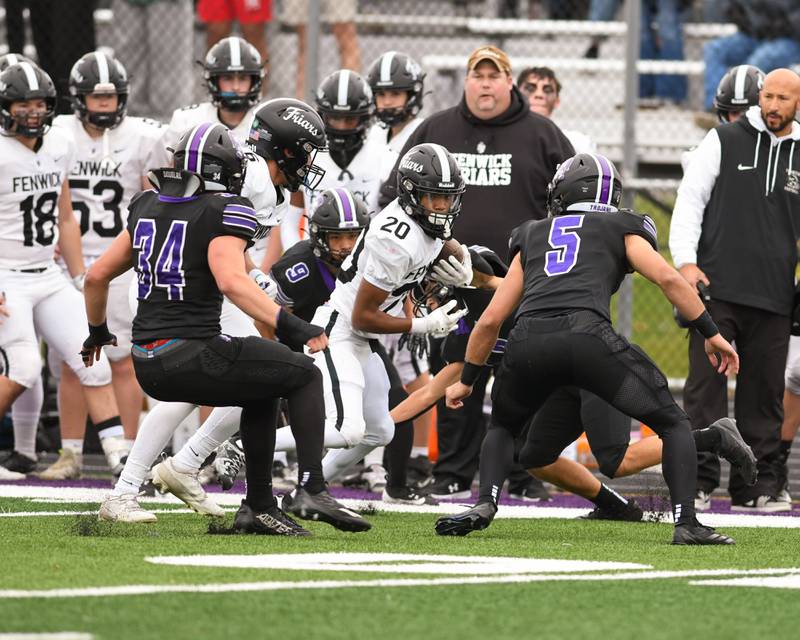 Fenwick's Raphiel Stewart (20) runs the ball during the second week of the class 3A game before being brought down by Downers Grove North defenders on Saturday Nov. 9, 2024, held at Downers Grove North.