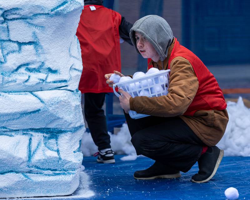 Kid looks to throw "snowball" whilst hiding behind "glacier" at the annual 'Ax Church Ultimate Snowball Fight' at Frosty on First on Saturday, November 8, 2025 on First Street in La Salle.