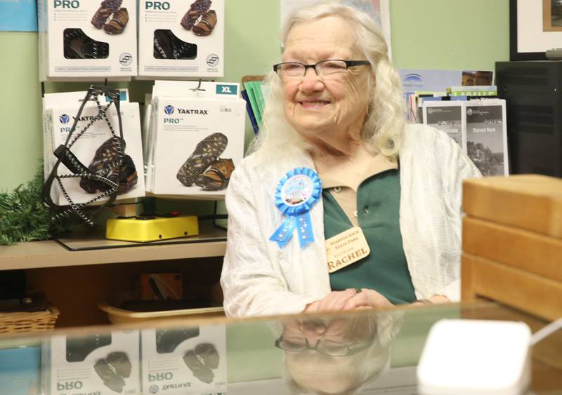 Rachel Mershon 94 of Granville, smiles while working behind the desk of the Starved Rock Bookstore on Monday, Sept. 22, 2025 inside the Starved Rock Visitors Center. Mershon turned 94 years-old and the staff celebrated her birthday with cake and cupcakes. Merschon drives to the Visitors Center every Monday to volunteer at the park ever since the bookstore opened in 2003. She has logged nearly 10,000 hours volunteering at the park.